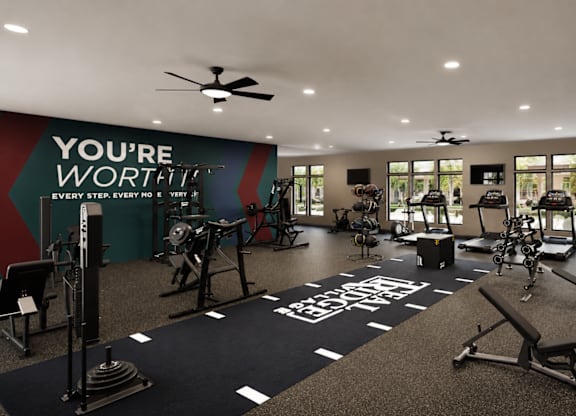 A gym with a variety of equipment and a motivational message on the wall.