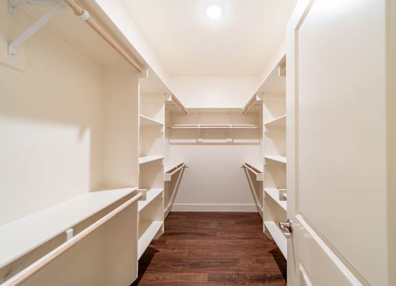 A long hallway with shelves on the side and a light on the ceiling.
