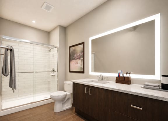 A bathroom with a toilet, sink, and mirror.