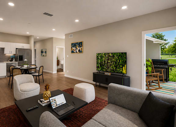A modern living room with a grey couch, a black coffee table, and a red rug.