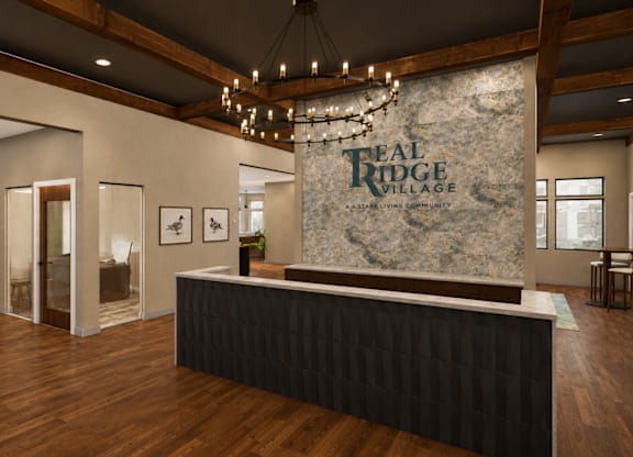 A reception area for Real Ridge Village Community with a stone backdrop and a black reception desk.