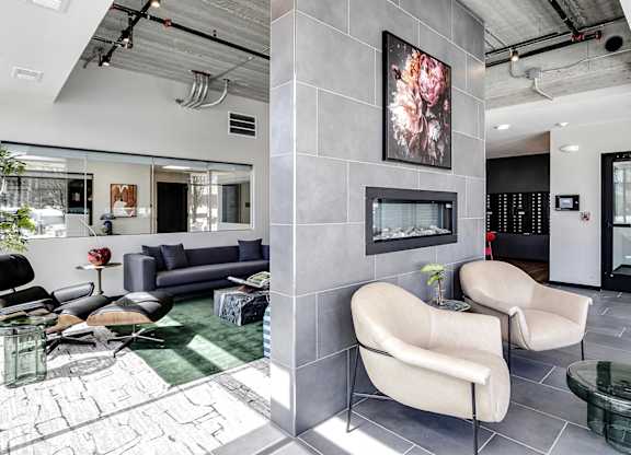 A modern waiting room with a large painting on the wall and comfortable seating.