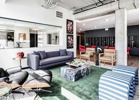 A living room with a grey sofa and a green rug.