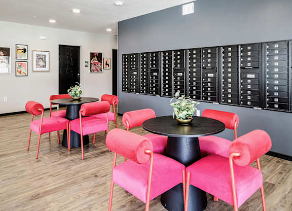 A room with a black table and red chairs.