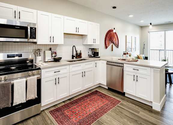 Brand new modern studio, one and two-bedroom apartment homes featuring stainless steel appliances, tile backsplash, quartz countertops, LVP flooring, large picture windows, in-unit washer and dryer and balconies at The Artisan at 39th in Omaha, NE