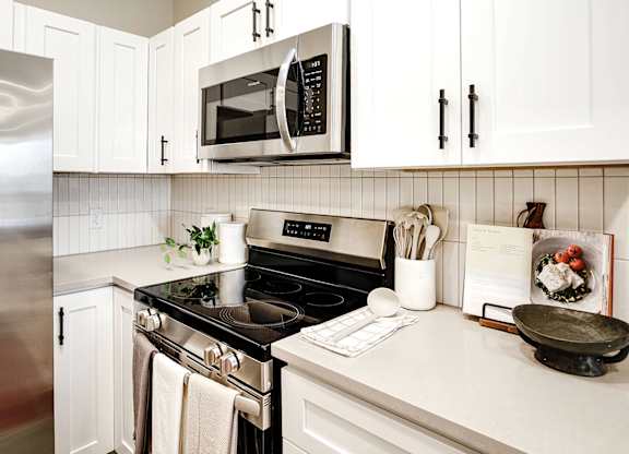 Brand new modern studio, one and two-bedroom apartment homes featuring stainless steel appliances, tile backsplash, quartz countertops, LVP flooring, large picture windows, in-unit washer and dryer and balconies at The Artisan at 39th in Omaha, NE