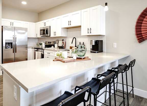 Brand new modern studio, one and two-bedroom apartment homes featuring stainless steel appliances, tile backsplash, quartz countertops, LVP flooring, large picture windows, in-unit washer and dryer and balconies at The Artisan at 39th in Omaha, NE
