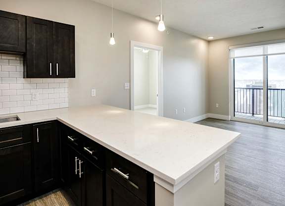 Brand new modern studio, one and two-bedroom apartment homes featuring stainless steel appliances, tile backsplash, quartz countertops, LVP flooring, large picture windows, in-unit washer and dryer and balconies at The Artisan at 39th in Omaha, NE