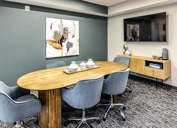 A conference room with a wooden table and chairs.