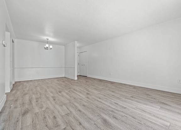 A room with light wood flooring and white walls.