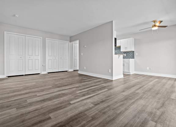 the living room of a house with white walls and a wood floor at Sunnymede Apartments - Troy, MI, Troy, Michigan