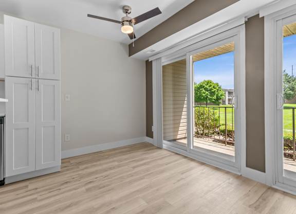 an empty living room with a sliding glass door to a balcony at Sunnymede Apartments - Troy, MI, Troy, MI