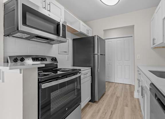 a renovated kitchen with stainless steel appliances and white cabinets at Sunnymede Apartments - Troy, MI, Troy, MI, 48084