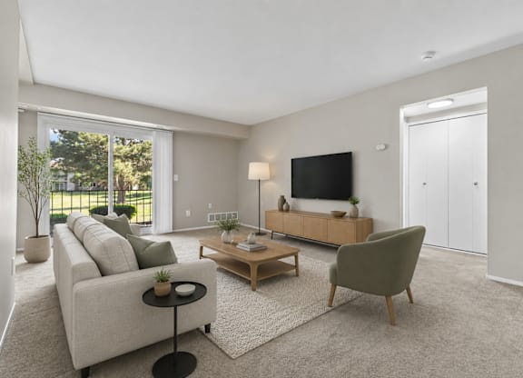 A living room with a grey couch, a wooden coffee table, and a green armchair.