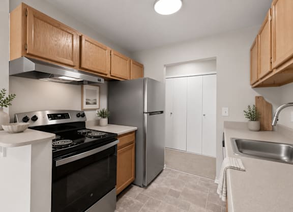 A kitchen with a black stove top oven and a silver refrigerator.