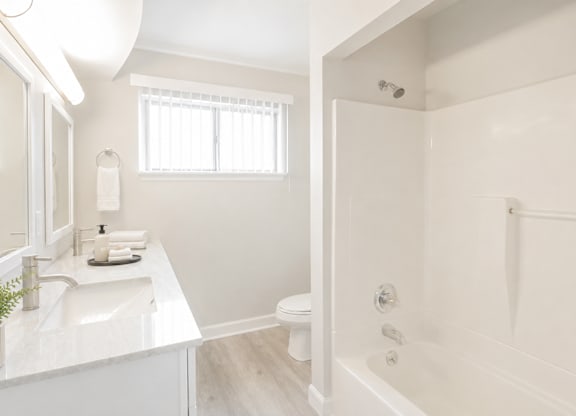 A white bathroom with a sink, toilet, and bathtub.