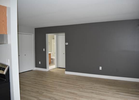 A room with a grey wall and wooden floor at Sunnymede Apartments in Troy, MI