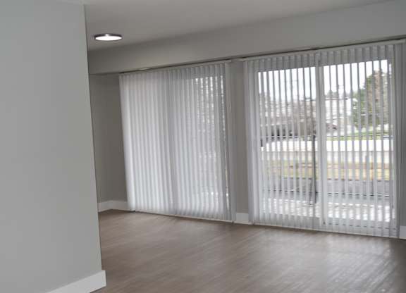 A room with a sliding door and a window with blinds at Sunnymede Apartments in Troy, MI