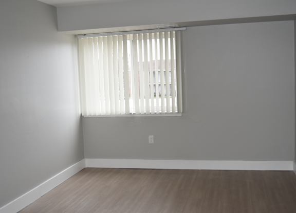 A room with a window covered by white blinds at Sunnymede Apartments in Troy, MI