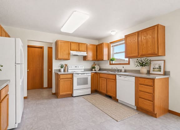 A kitchen with wooden cabinets and white appliances.