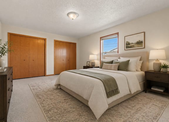 A bedroom with a large bed and a window.