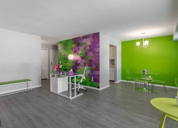 a room with a green wall and a white table and chairs