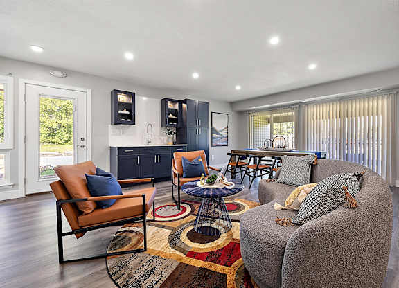 a living room with a couch and a table at Sunnymede Apartments - Troy, MI, Michigan