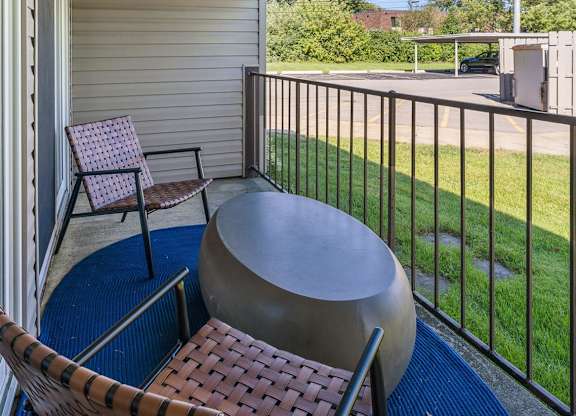 a patio with two chairs and a table on a balcony at Sunnymede Apartments - Troy, MI, Troy, 48084