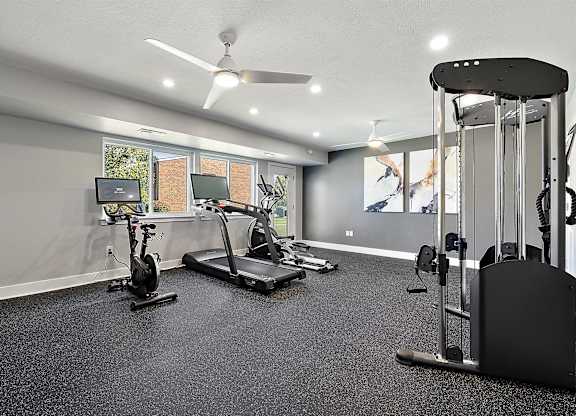 a home gym with exercise equipment and a tv at Sunnymede Apartments - Troy, MI, Troy