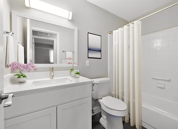 a bathroom with a toilet sink and a shower at Sunnymede Apartments - Troy, MI, Michigan