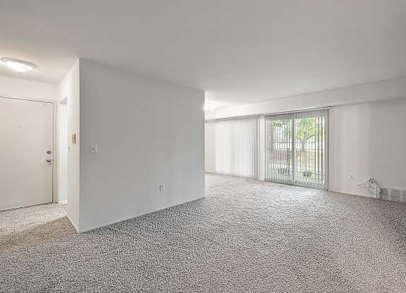 an empty living room with white walls and a window at Sunnymede Apartments - Troy, MI, Troy, MI