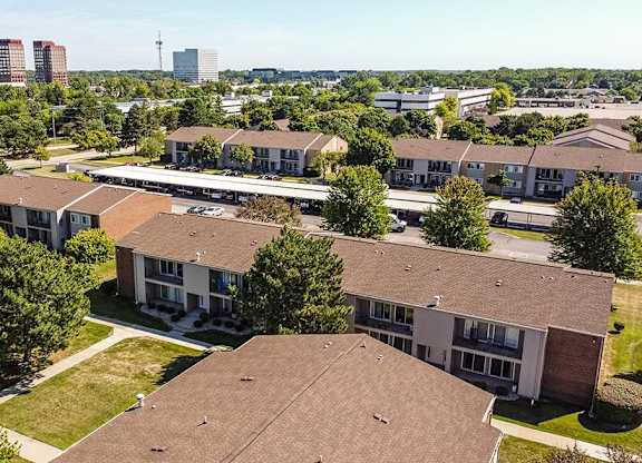 an aerial view of houses in a neighborhood with a city in the background at Sunnymede Apartments - Troy, MI, Troy