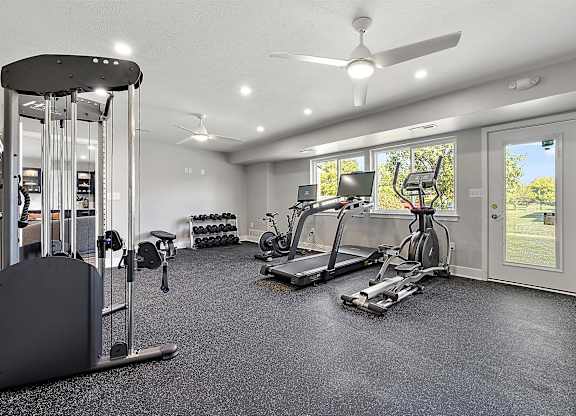 a home gym with exercise equipment and a window at Sunnymede Apartments - Troy, MI, Troy, Michigan