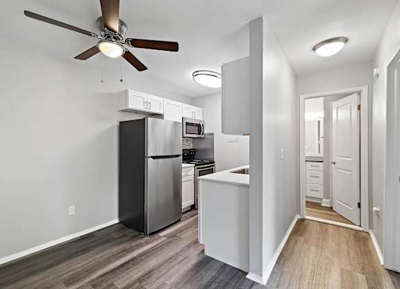 a kitchen with a refrigerator and a ceiling fan at Town & Country Apartments - Wixom, MI, Wixom, 48393