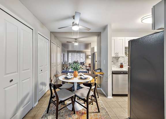 an open kitchen and dining room with a table and chairs at Town & Country Apartments - Wixom, MI, Wixom