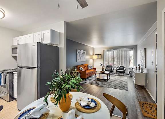 a kitchen and living room with a refrigerator and a table at Town & Country Apartments - Wixom, MI, Michigan