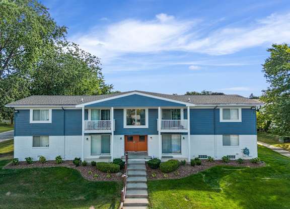 the view of a blue and white house with a orange door at Town & Country Apartments - Wixom, MI, Wixom