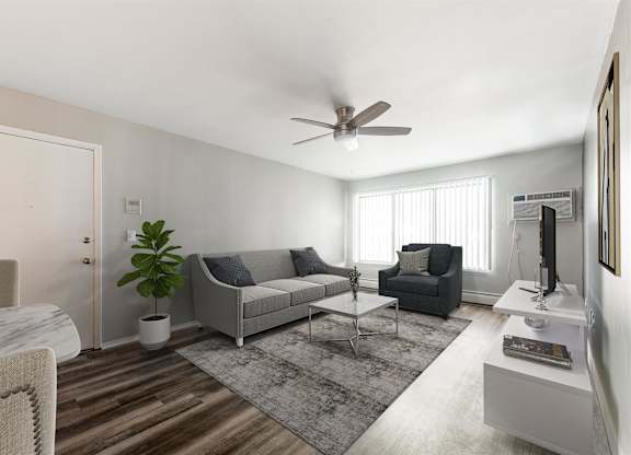 a living room with couches and a coffee table at Town & Country Apartments - Wixom, MI, Wixom
