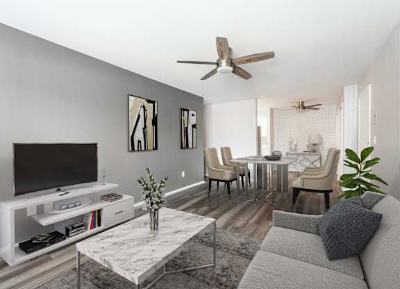 a living room with a couch and a tv at Town & Country Apartments - Wixom, MI, Wixom, 48393