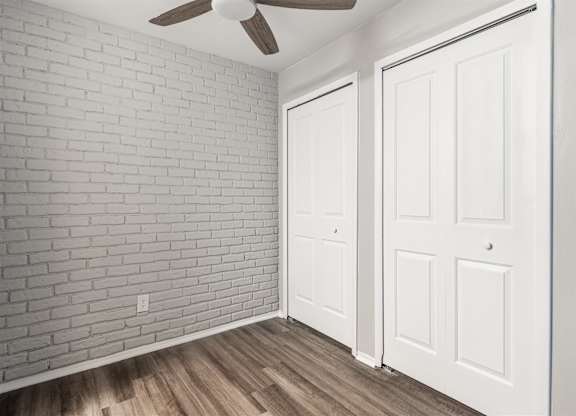 an empty room with white doors and a ceiling fan at Town & Country Apartments - Wixom, MI, Michigan