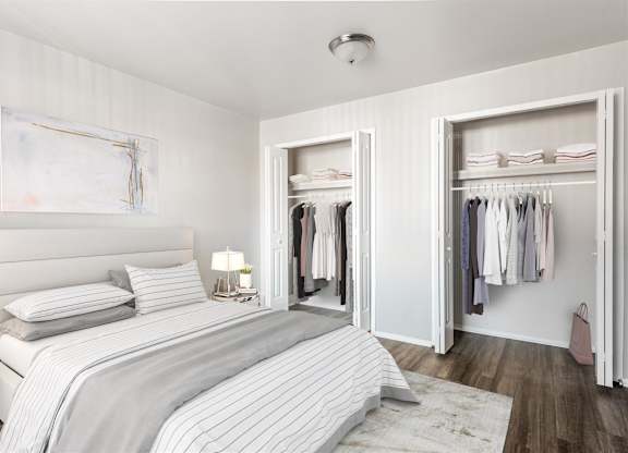 a bedroom with a bed and a closet at Town & Country Apartments - Wixom, MI, Wixom, Michigan
