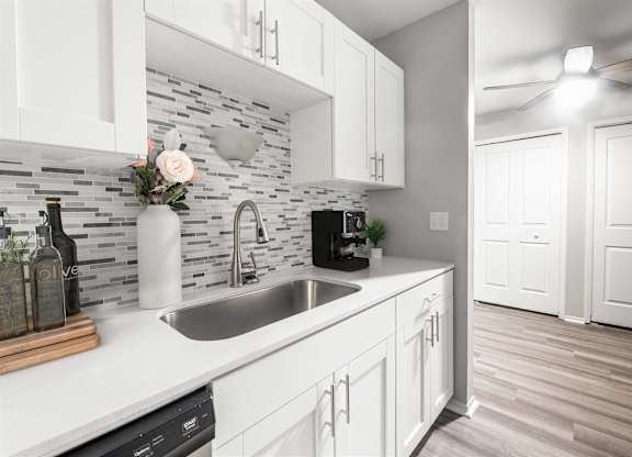 a kitchen with white cabinets and a sink1 at Town & Country Apartments - Wixom, MI, Wixom