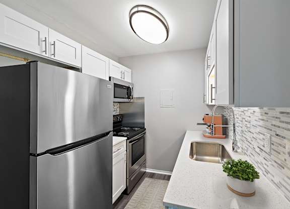 a kitchen with stainless steel appliances and a sink at Town & Country Apartments - Wixom, MI, Wixom, 48393