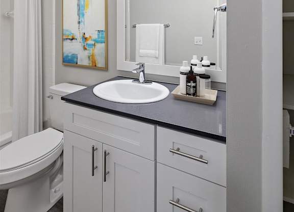white bathroom with a sink at Town & Country Apartments - Wixom, MI, Wixom