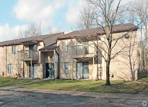 a building with two balconies and a tree in front of it
