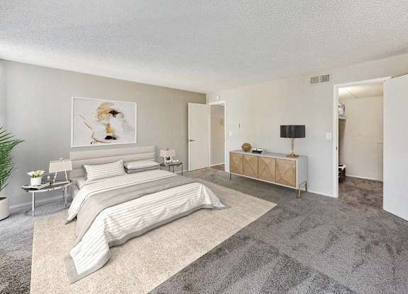 A bedroom with a large bed and a bench at The Waverly on the Lake - Belleville, MI Apartment , Belleville