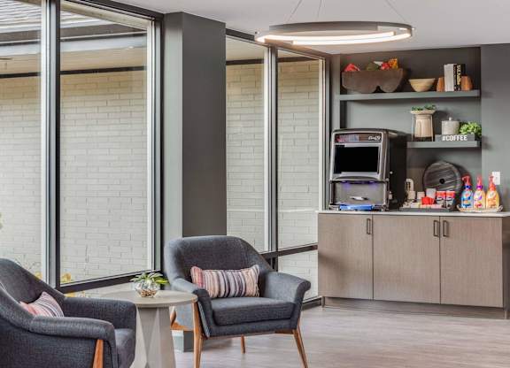 A modern living room with grey armchairs and a grey coffee table at The Waverly on the Lake - Belleville, MI Apartment , Michigan