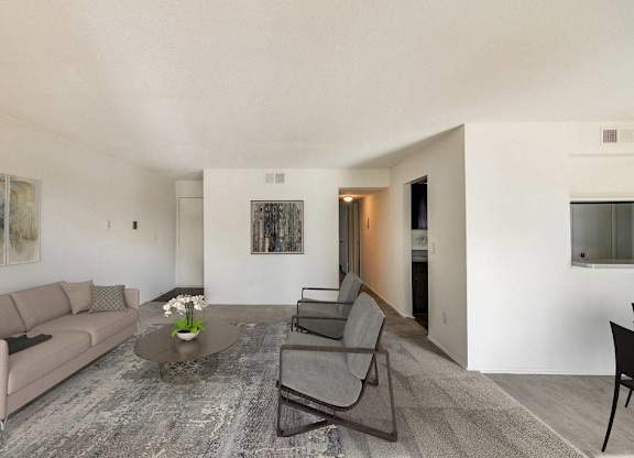 A living room with a grey couch, a coffee table, and a painting on the wall at The Waverly on the Lake - Belleville, MI Apartment , Belleville