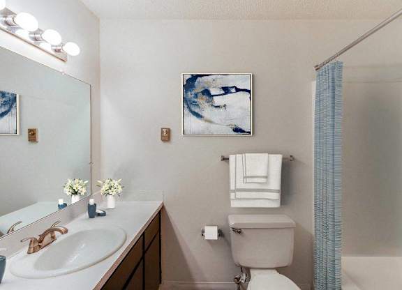 A bathroom with a toilet, sink, and shower at The Waverly on the Lake - Belleville, MI Apartment , Belleville, MI