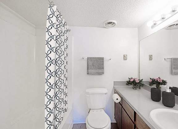 A white toilet sits in a bathroom next to a sink at The Waverly on the Lake - Belleville, MI Apartment , Belleville, MI